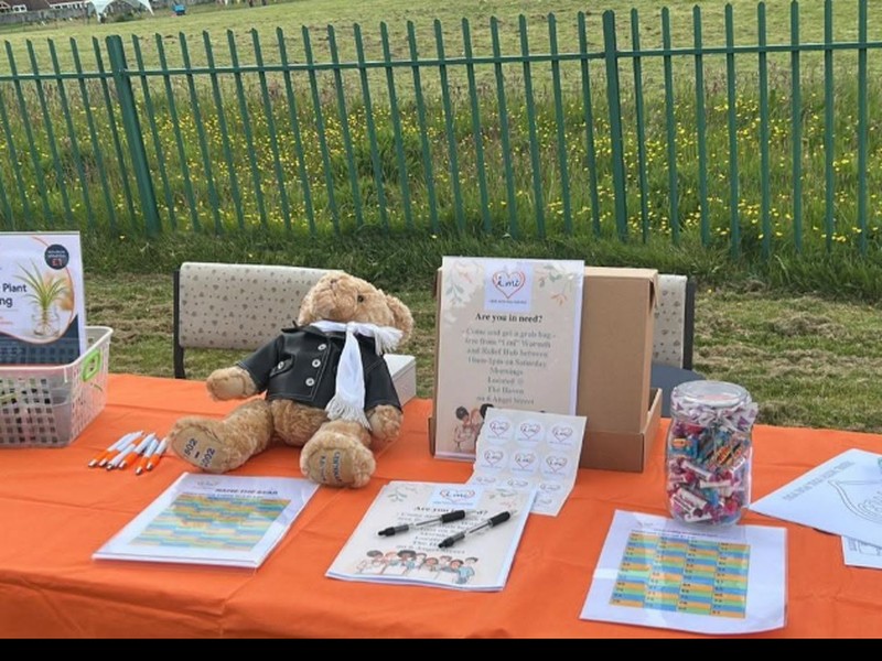 'i mi' CASS outreach stall at a community fete, with activities, a plant giveaway, and information for local residents